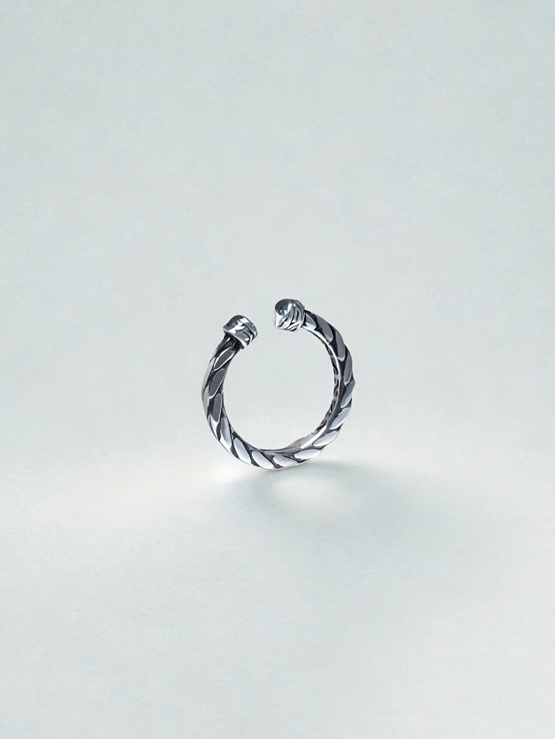 Silver twisted ring on a light gray background
