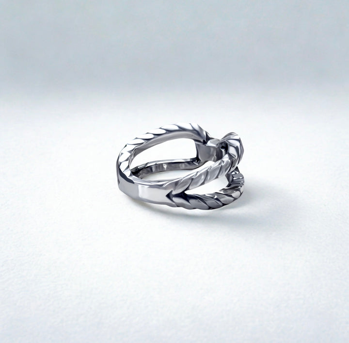 Silver ring with a textured design on a light gray background
